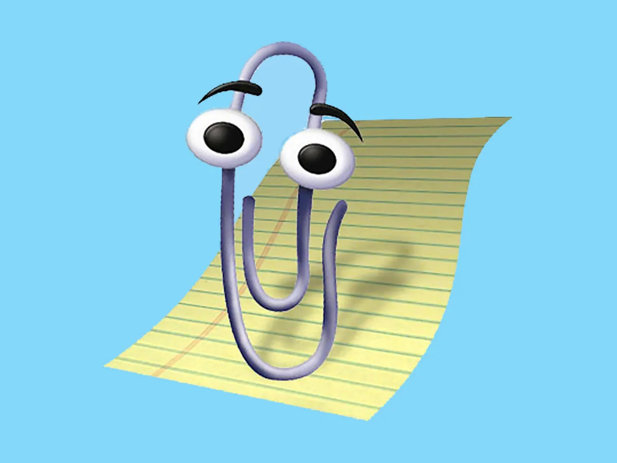 Clippy, Microsoft's animated paperclip, raises his eyebrows in front of a yellow lined note on a bright blue background.